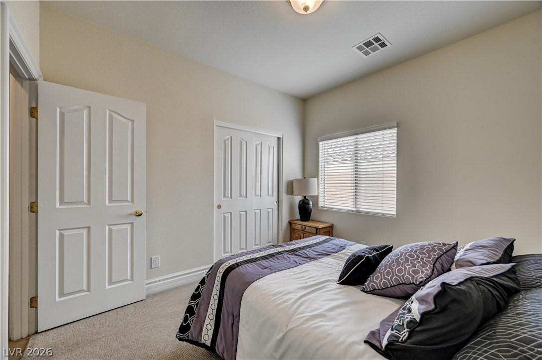 2201 Double Tree Avenue, Henderson, NV 89052 Soft carpeting pairs with a multi-panel closet door in this cozy, light-filled bedroom.