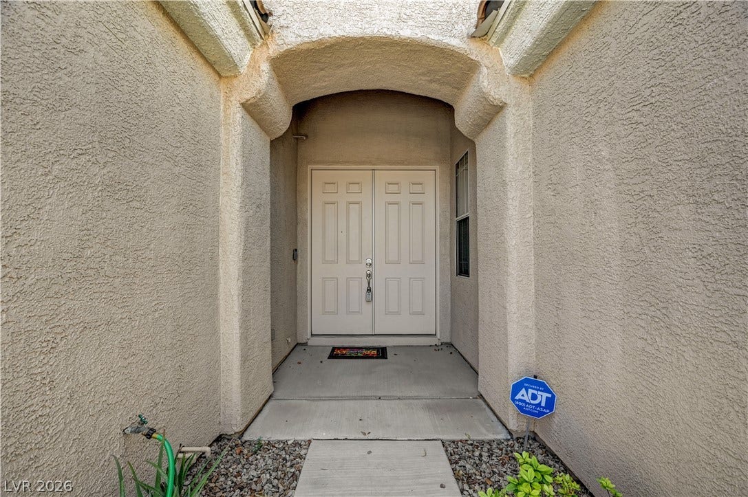 2201 Double Tree Avenue, Henderson, NV 89052 An arched stucco entryway features double front doors leading into the home.