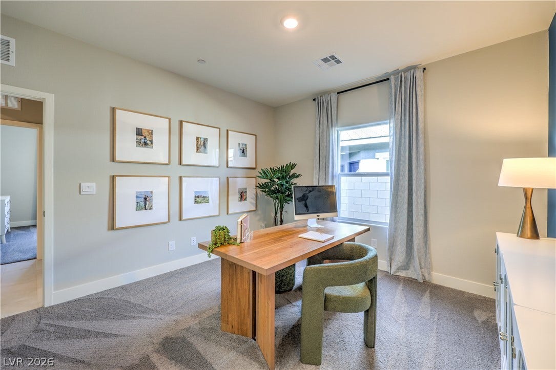 1032 Gentle Swan Street, Henderson, NV 89011 A spacious home workspace is enhanced by plush carpeting and a large window.