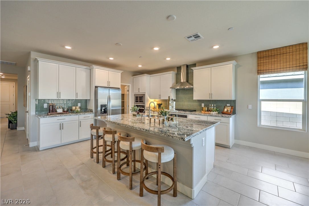 1032 Gentle Swan Street, Henderson, NV 89011 An open kitchen layout boasts an expansive prep island and classic tiled flooring.