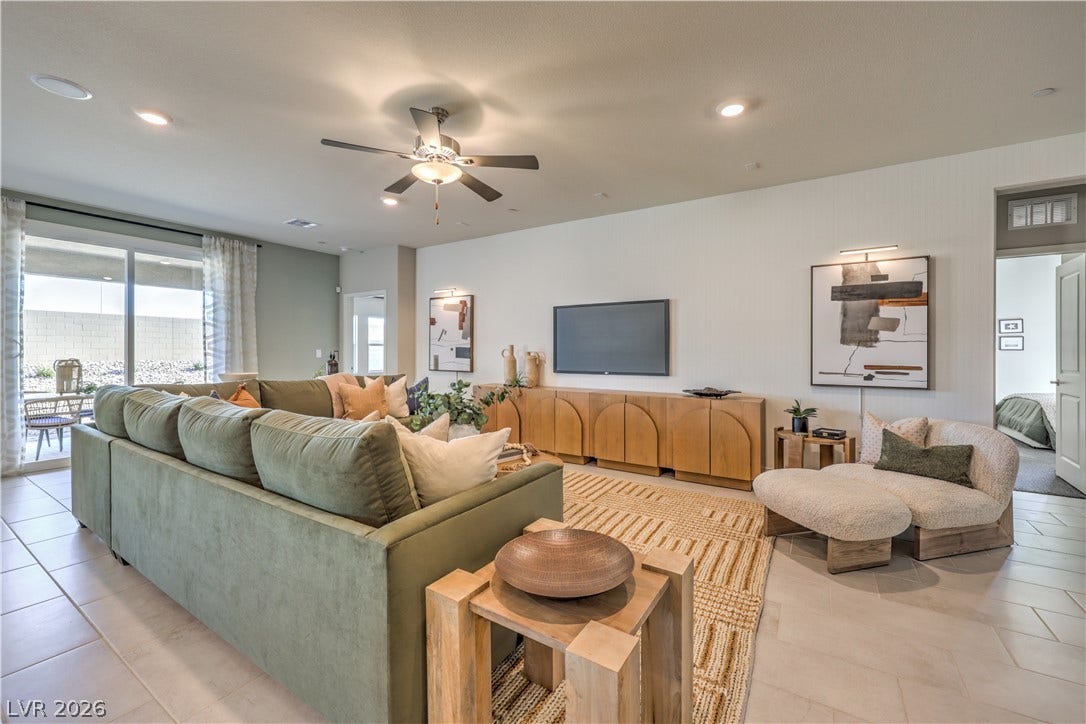 1032 Gentle Swan Street, Henderson, NV 89011 An open living room features tile flooring and sliding glass doors to the patio.