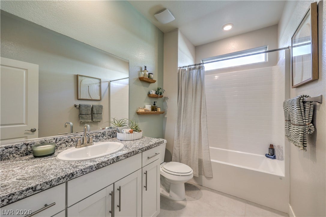 1032 Gentle Swan Street, Henderson, NV 89011 Granite countertops and clean tile surrounds accent this modern full bathroom.