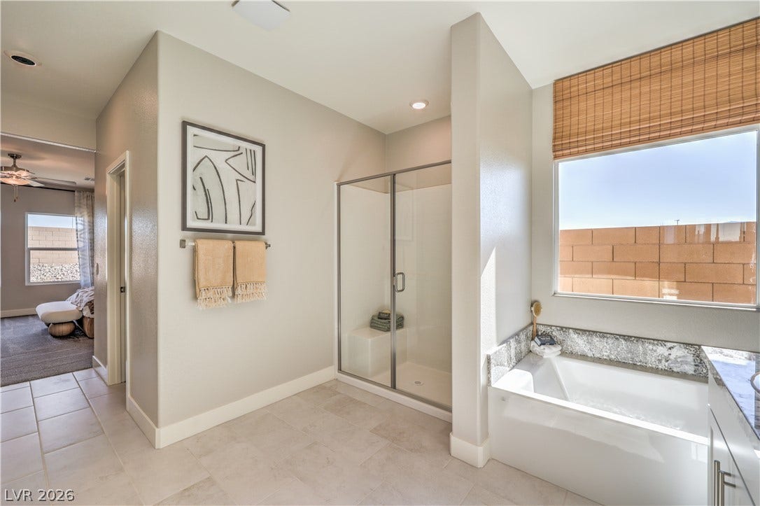 1032 Gentle Swan Street, Henderson, NV 89011 An inviting soaking tub and glass-enclosed walk-in shower complement the modern tile flooring.