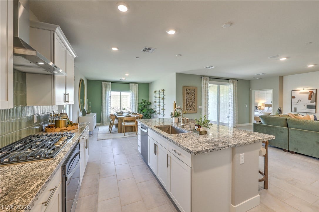 1032 Gentle Swan Street, Henderson, NV 89011 An open-concept layout connects the kitchen, dining, and living areas seamlessly under recessed lighting.