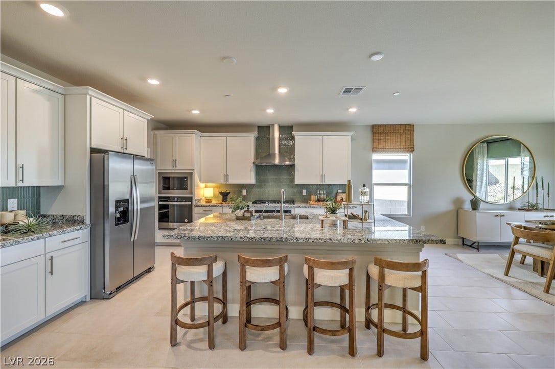 1032 Gentle Swan Street, Henderson, NV 89011 An expansive kitchen features granite countertops, a large center island, and modern stainless steel appliances.
