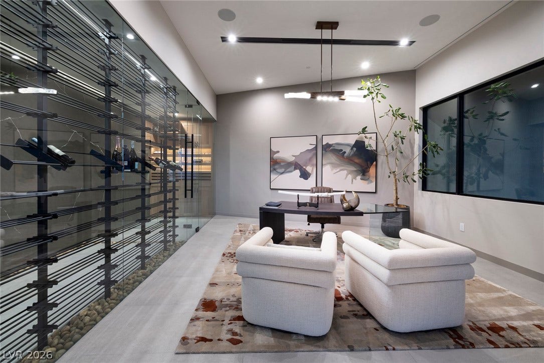705 Dragon Peak Drive, Henderson, NV 89012 A glass-enclosed wine wall runs alongside this modern home office with recessed lighting.
