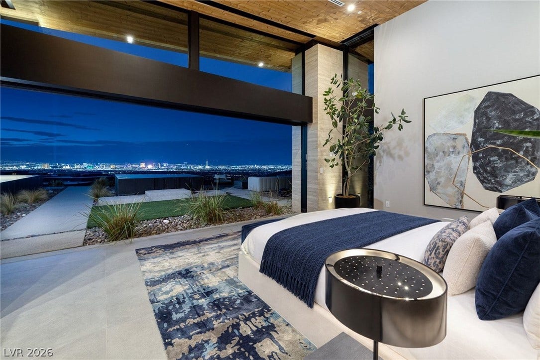 705 Dragon Peak Drive, Henderson, NV 89012 Massive sliding glass walls reveal a breathtaking city skyline panorama from this modern bedroom.