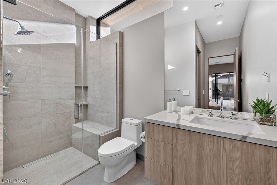 705 Dragon Peak Drive, Henderson, NV 89012 Clean lines and large format wall tiles define this modern bathroom with walk-in shower.