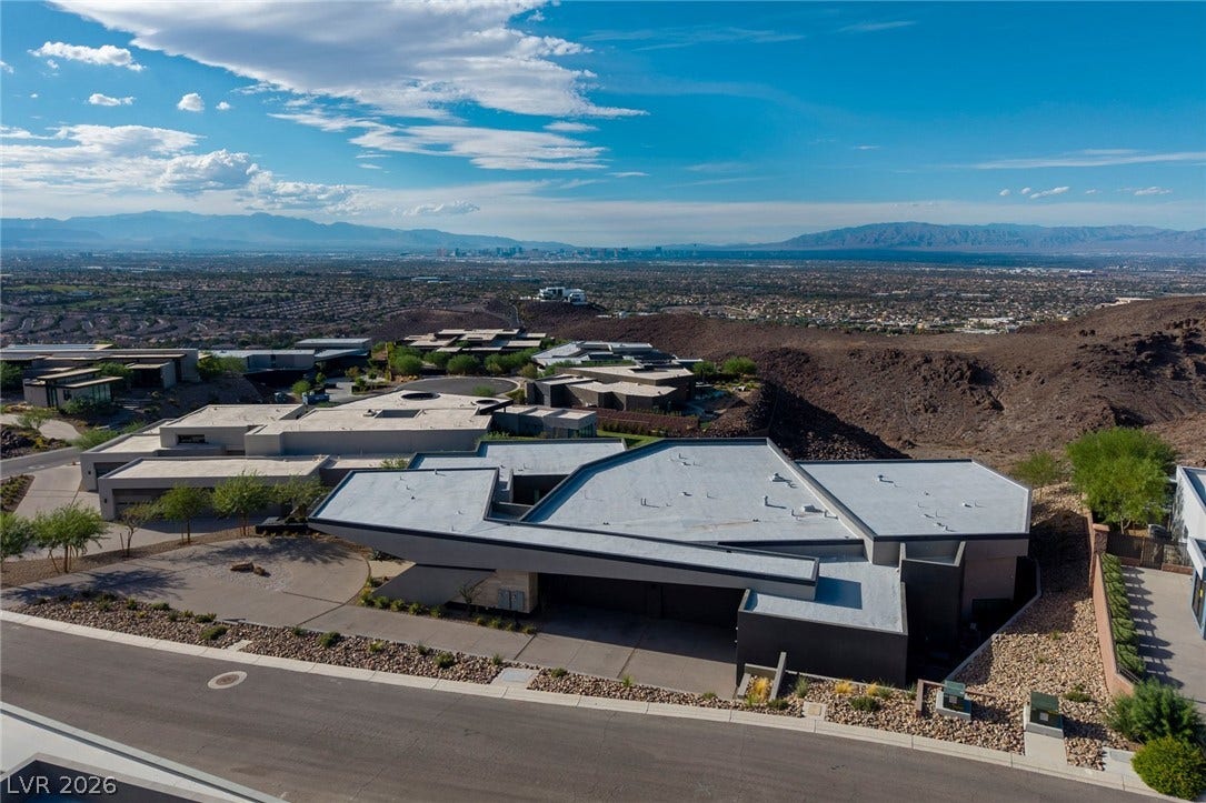 705 Dragon Peak Drive, Henderson, NV 89012 Dramatic modern architecture commands attention against a sweeping backdrop of desert and distant city skylines.