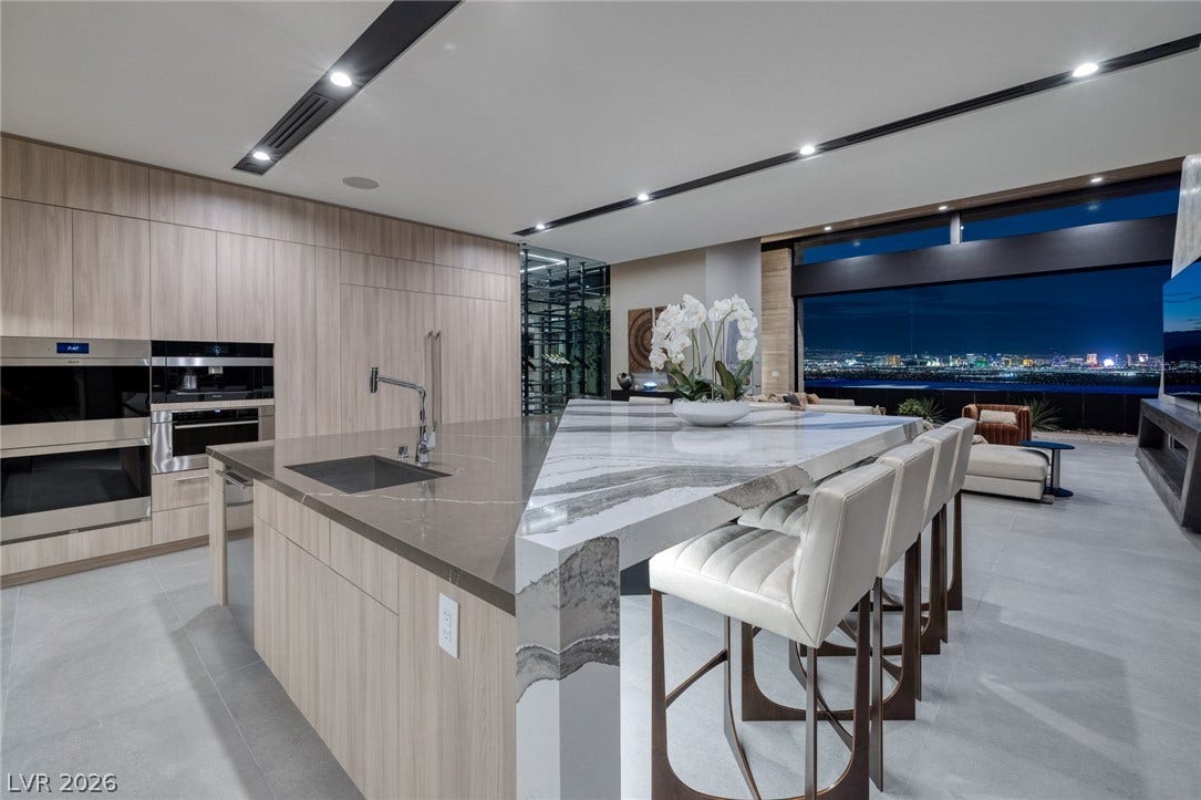 705 Dragon Peak Drive, Henderson, NV 89012 Clean lines and stone countertops define this modern culinary space showcasing panoramic city skyline views.