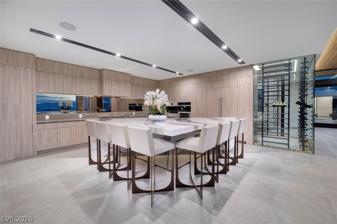 705 Dragon Peak Drive, Henderson, NV 89012 A spacious kitchen presents minimalist cabinetry and a large marble island under recessed linear lighting.
