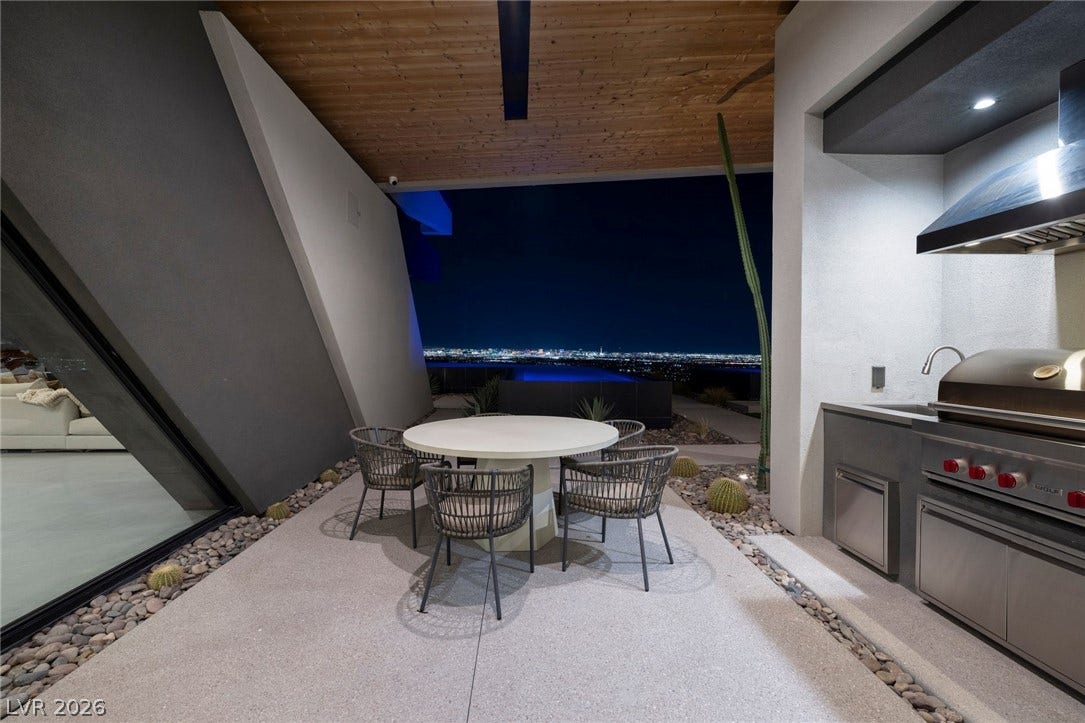 705 Dragon Peak Drive, Henderson, NV 89012 A modern outdoor kitchen on a covered patio looks out over twinkling city lights.