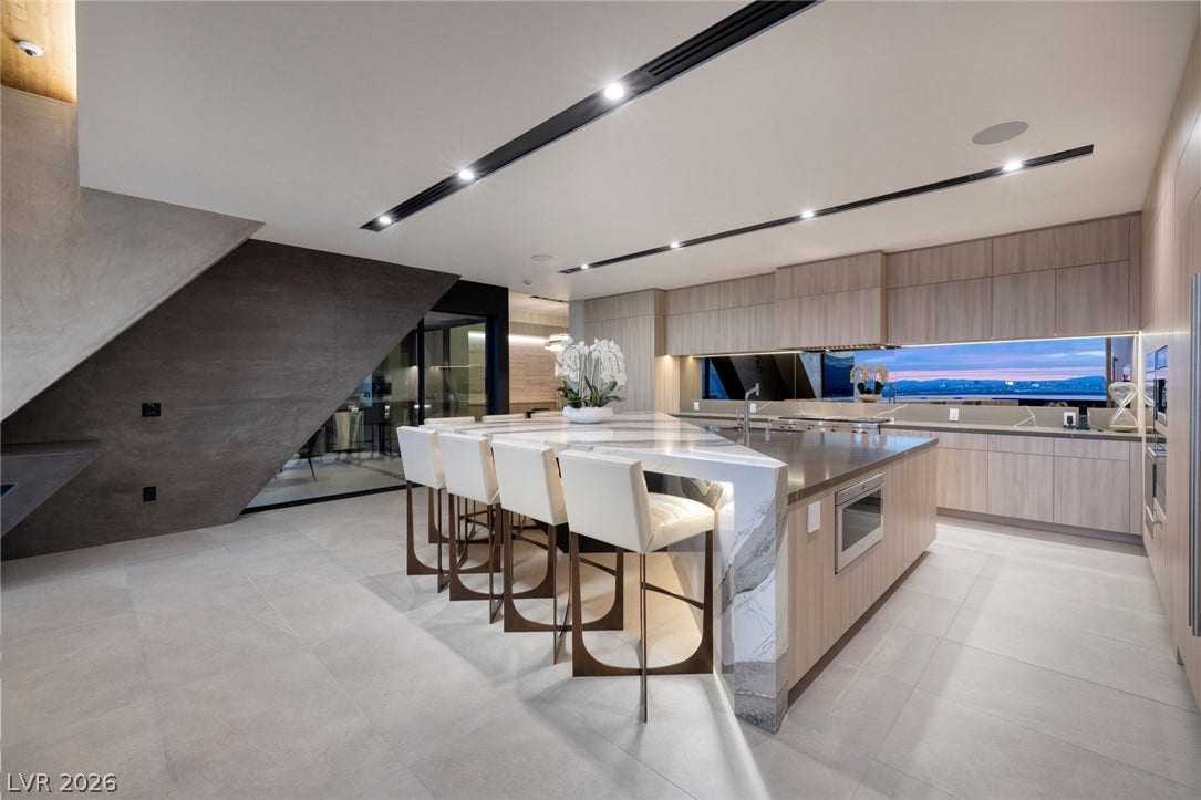 705 Dragon Peak Drive, Henderson, NV 89012 Clean architectural lines and custom stone surfaces define this modern, light-filled kitchen space.