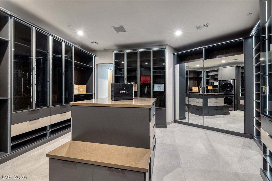 705 Dragon Peak Drive, Henderson, NV 89012 Custom floor-to-ceiling wardrobes and a massive central island anchor this sleek dressing room.