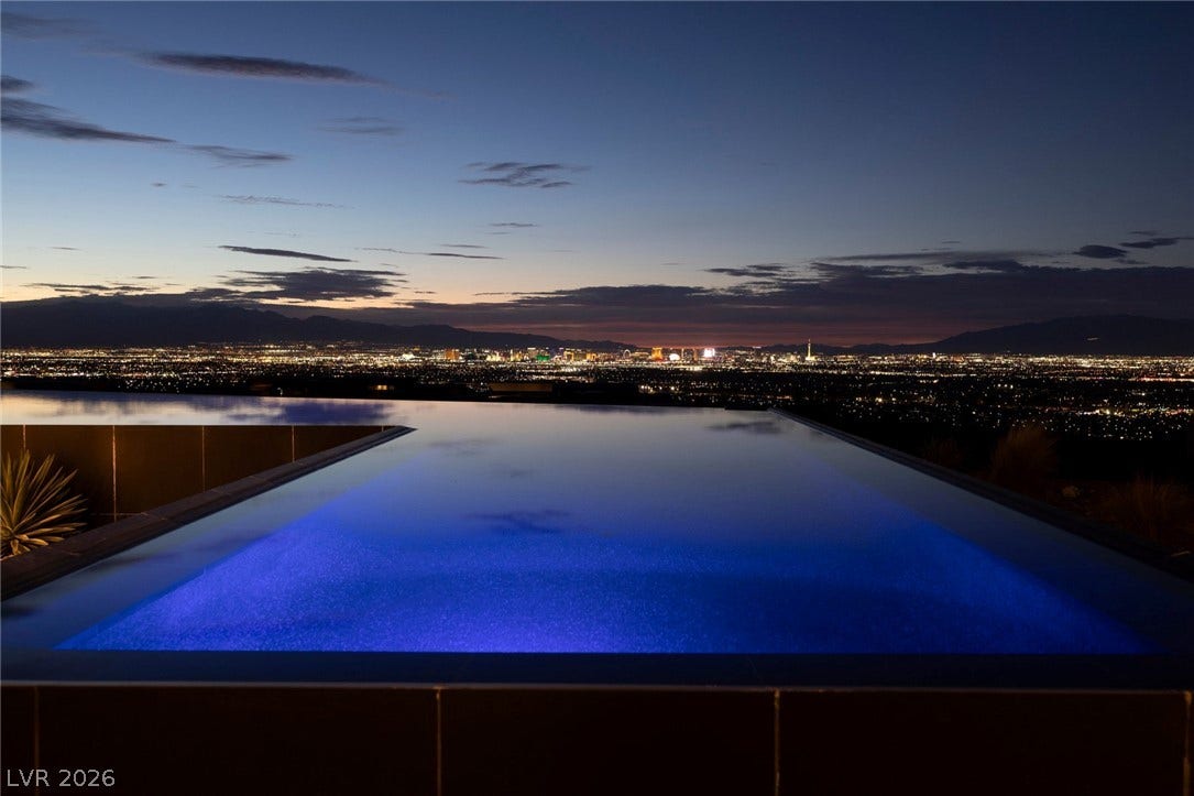 705 Dragon Peak Drive, Henderson, NV 89012 Glistening infinity pool frames sweeping twilight vistas of the distant city skyline.