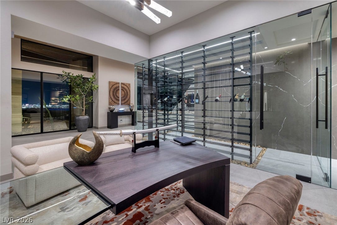 705 Dragon Peak Drive, Henderson, NV 89012 Sleek glass walls frame a temperature-controlled wine room adjacent to a modern home office.