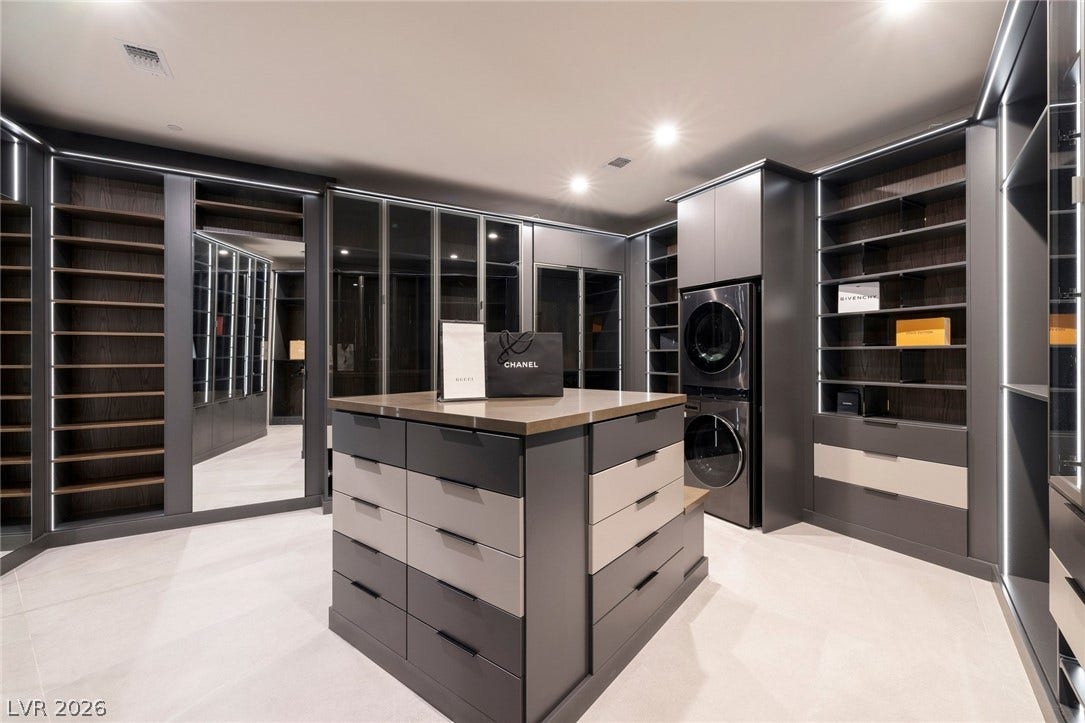 705 Dragon Peak Drive, Henderson, NV 89012 Custom cabinetry and integrated laundry appliances define this custom walk-in closet.