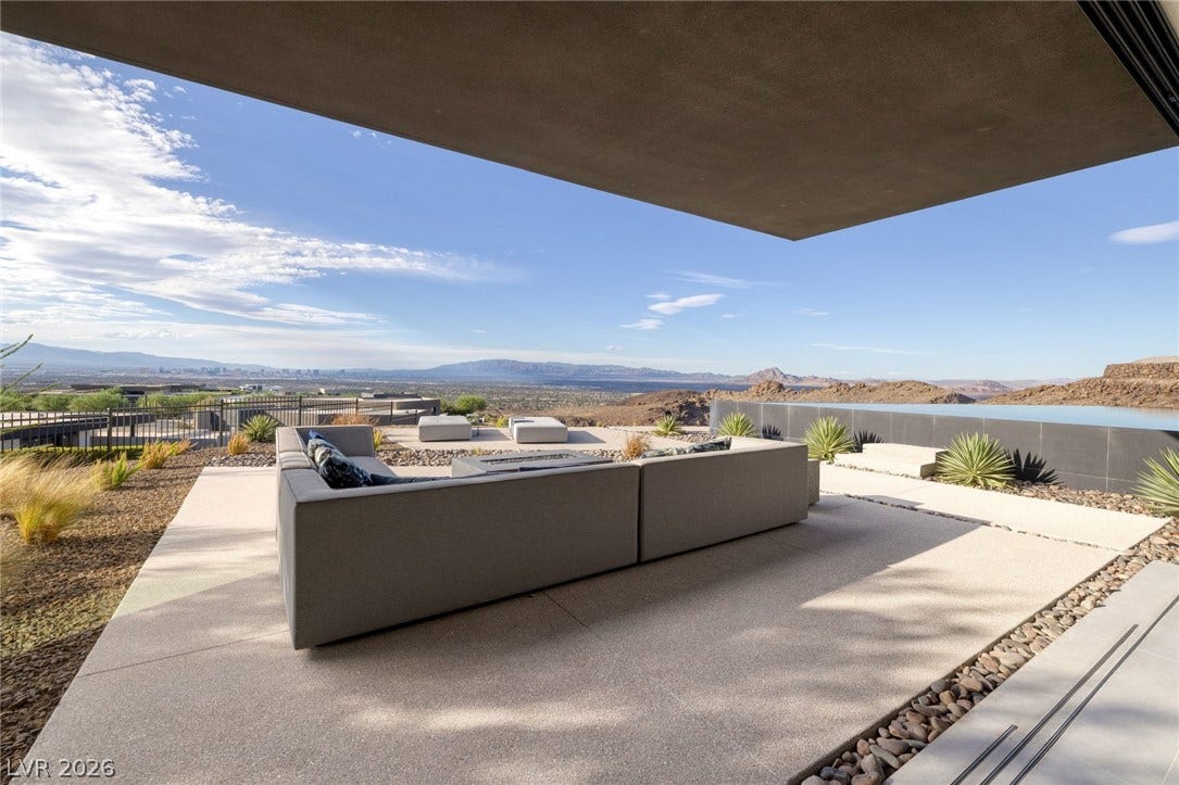 705 Dragon Peak Drive, Henderson, NV 89012 A sheltered concrete terrace overlooks a modern infinity pool and distant mountain ranges.