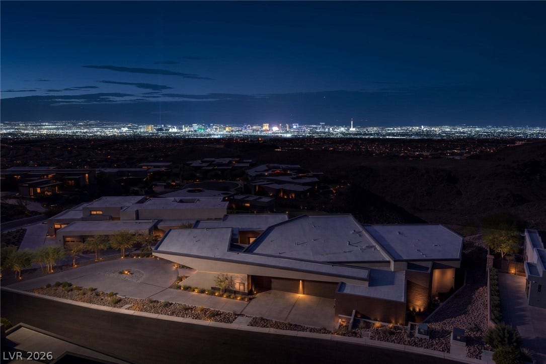 705 Dragon Peak Drive, Henderson, NV 89012 Dramatic modern architecture stands in bold contrast against a sprawling, brilliant city skyline at night.