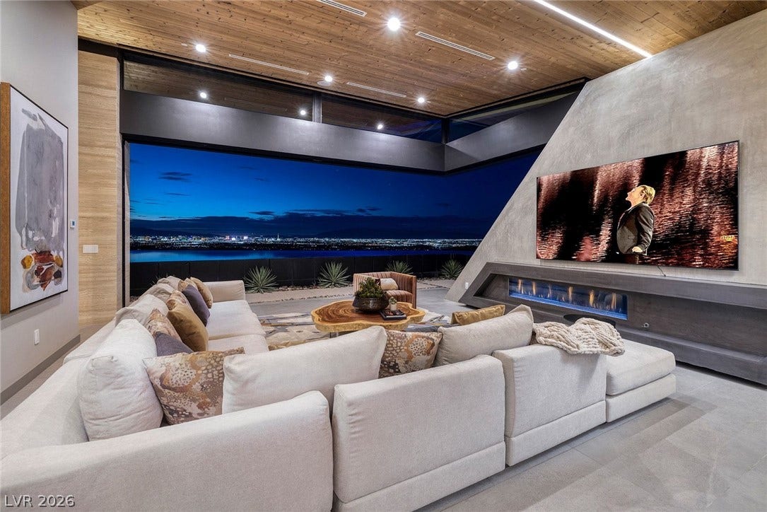 705 Dragon Peak Drive, Henderson, NV 89012 Retracting glass walls merge a contemporary living area with a dramatic city lights backdrop.