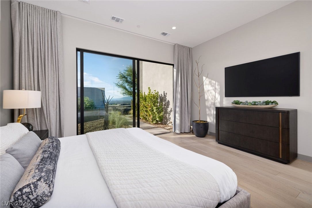 705 Dragon Peak Drive, Henderson, NV 89012 Sliding glass doors open directly to the tranquil outdoor spaces from this serene bedroom.