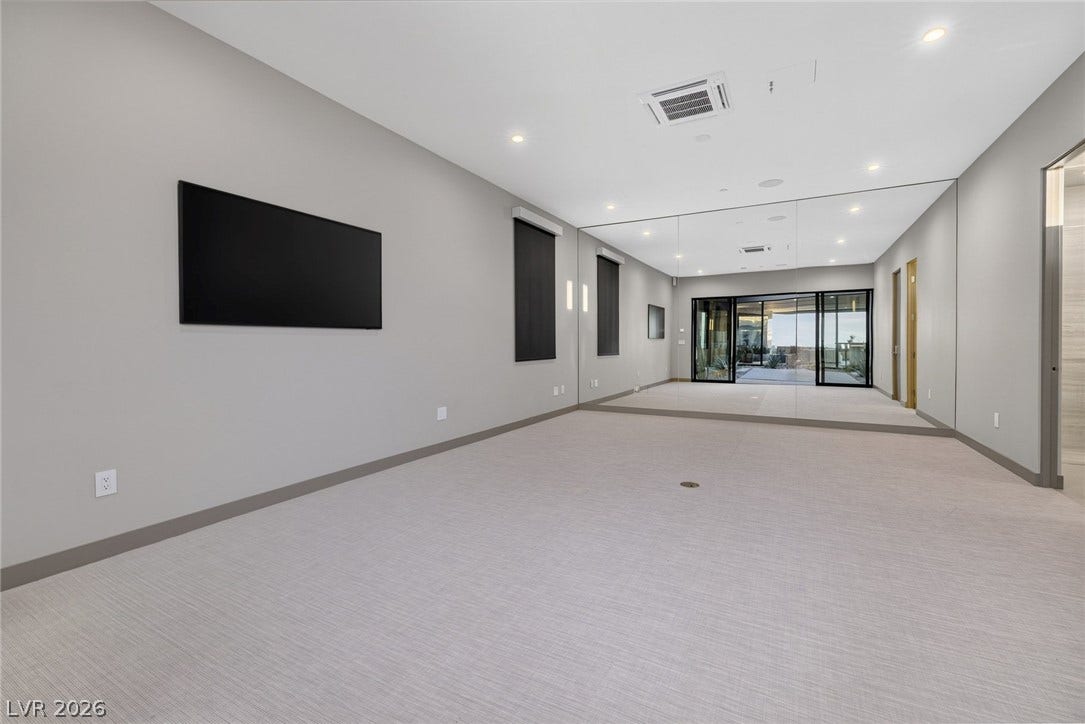 705 Dragon Peak Drive, Henderson, NV 89012 An expansive mirrored wall and recessed lighting highlight this versatile home gym space.