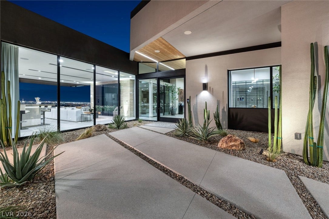 705 Dragon Peak Drive, Henderson, NV 89012 Geometric concrete pathways guide visitors toward a contemporary glass entrance set against desert landscaping.