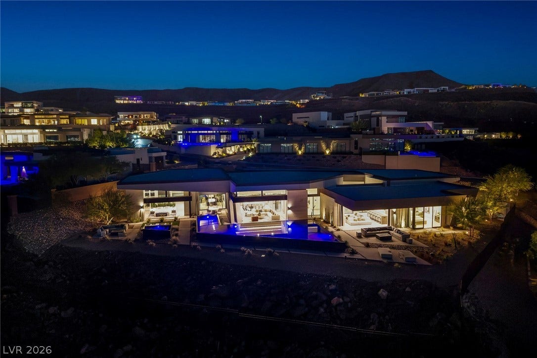 705 Dragon Peak Drive, Henderson, NV 89012 Dramatic mountain backdrops frame a modern desert estate with expansive glass walls and integrated pools.