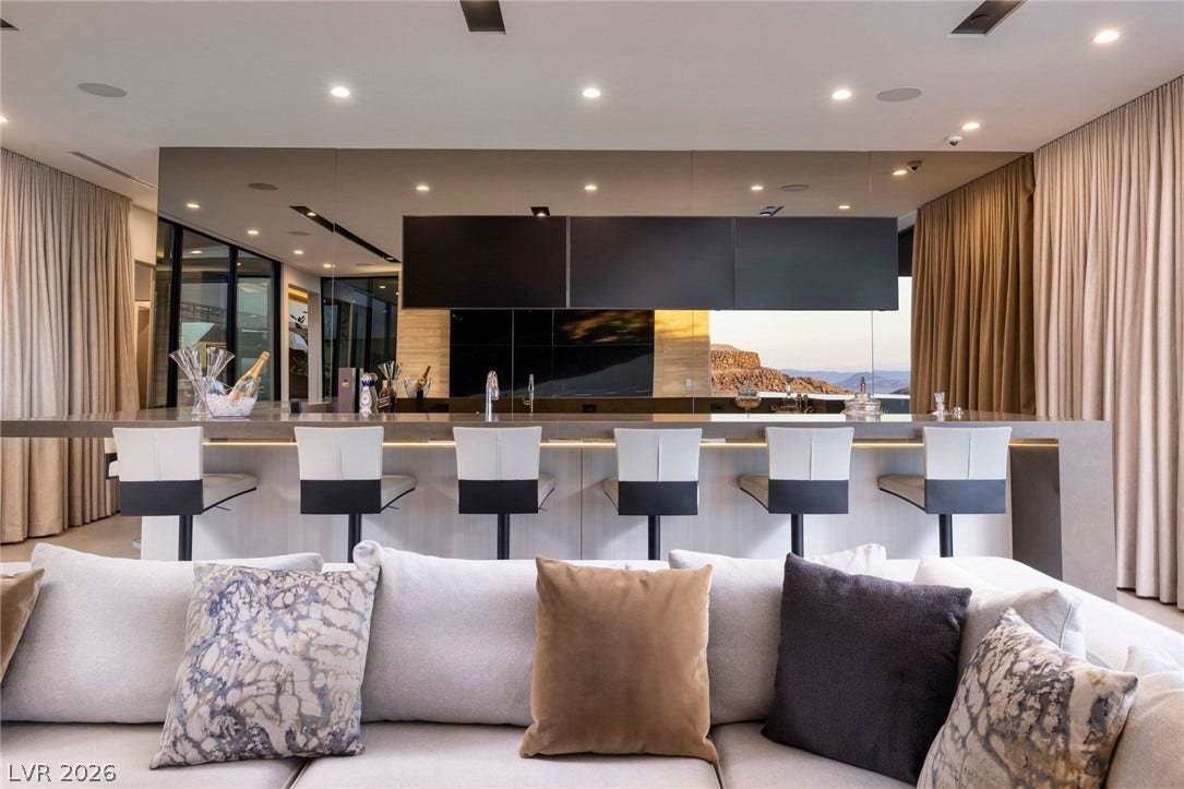 705 Dragon Peak Drive, Henderson, NV 89012 Recessed lighting glows above a sleek built-in bar counter with high-end stone finishes.