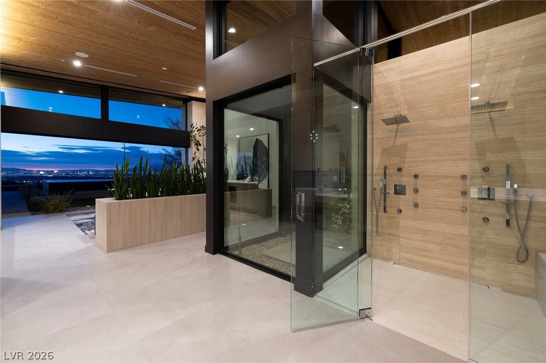 705 Dragon Peak Drive, Henderson, NV 89012 An open glass shower stands on sleek tile flooring beneath a wood-paneled ceiling.