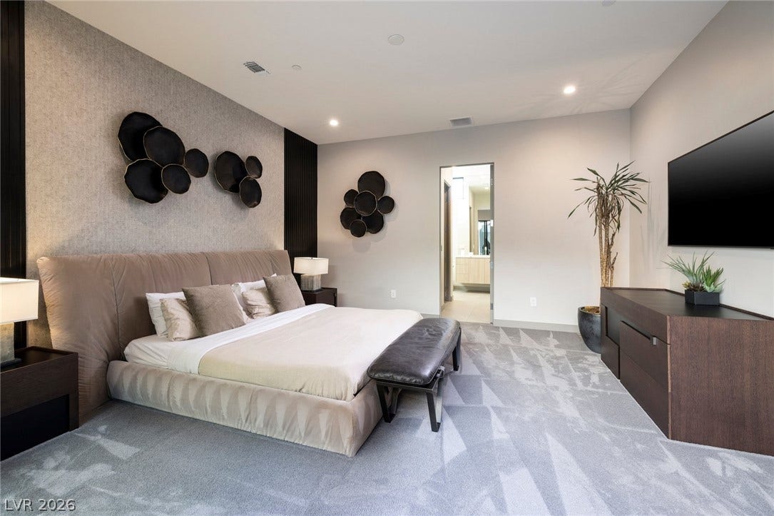 705 Dragon Peak Drive, Henderson, NV 89012 Recessed lighting and plush carpeting define this serene bedroom suite with bathroom access.