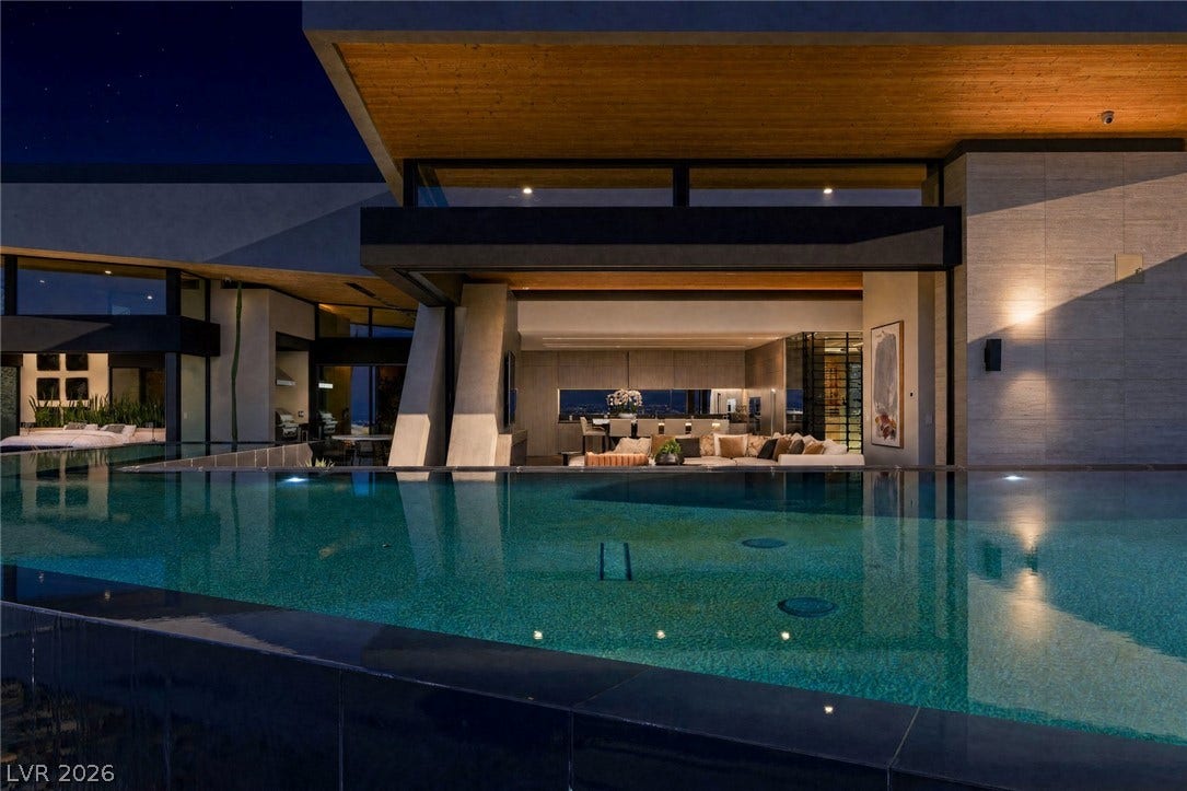 705 Dragon Peak Drive, Henderson, NV 89012 An architectural masterpiece opens seamlessly to a sparkling infinity-edge pool under wood-paneled ceilings.