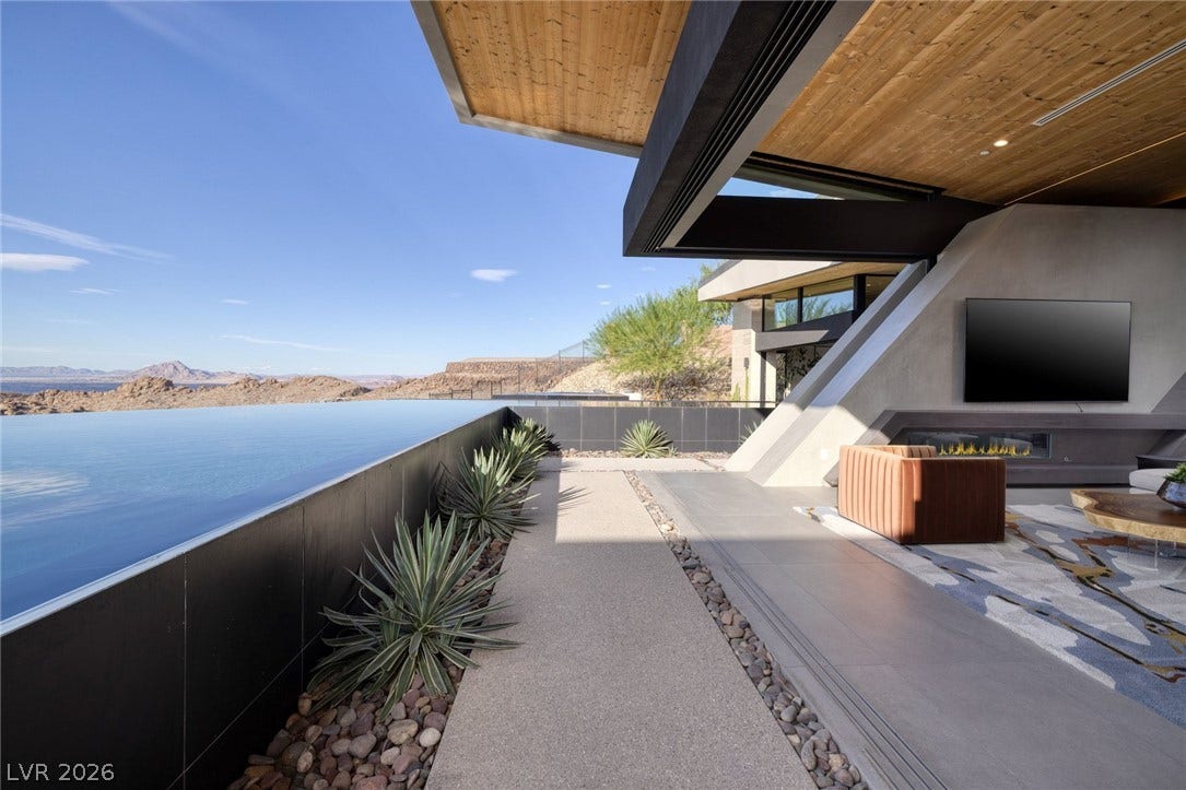 705 Dragon Peak Drive, Henderson, NV 89012 An architectural overhang shelters a tiled terrace beside a seamless infinity pool.