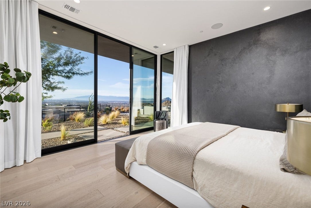 705 Dragon Peak Drive, Henderson, NV 89012 Massive sliding glass doors reveal panoramic valley views from this contemporary bedroom.