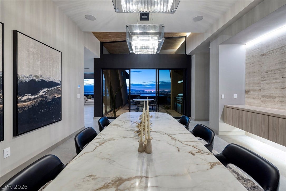 705 Dragon Peak Drive, Henderson, NV 89012 A spacious formal dining room connects seamlessly to an outdoor terrace through glass sliding doors.