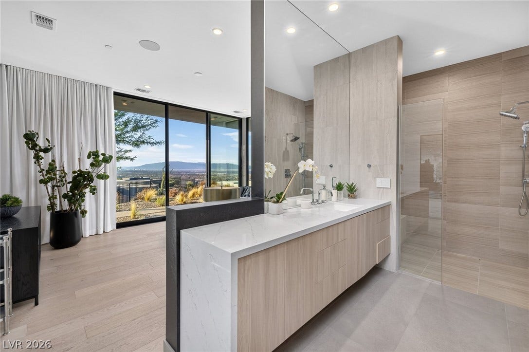 705 Dragon Peak Drive, Henderson, NV 89012 A floating dual vanity sits adjacent to a glass-enclosed walk-in shower with scenic horizon views.
