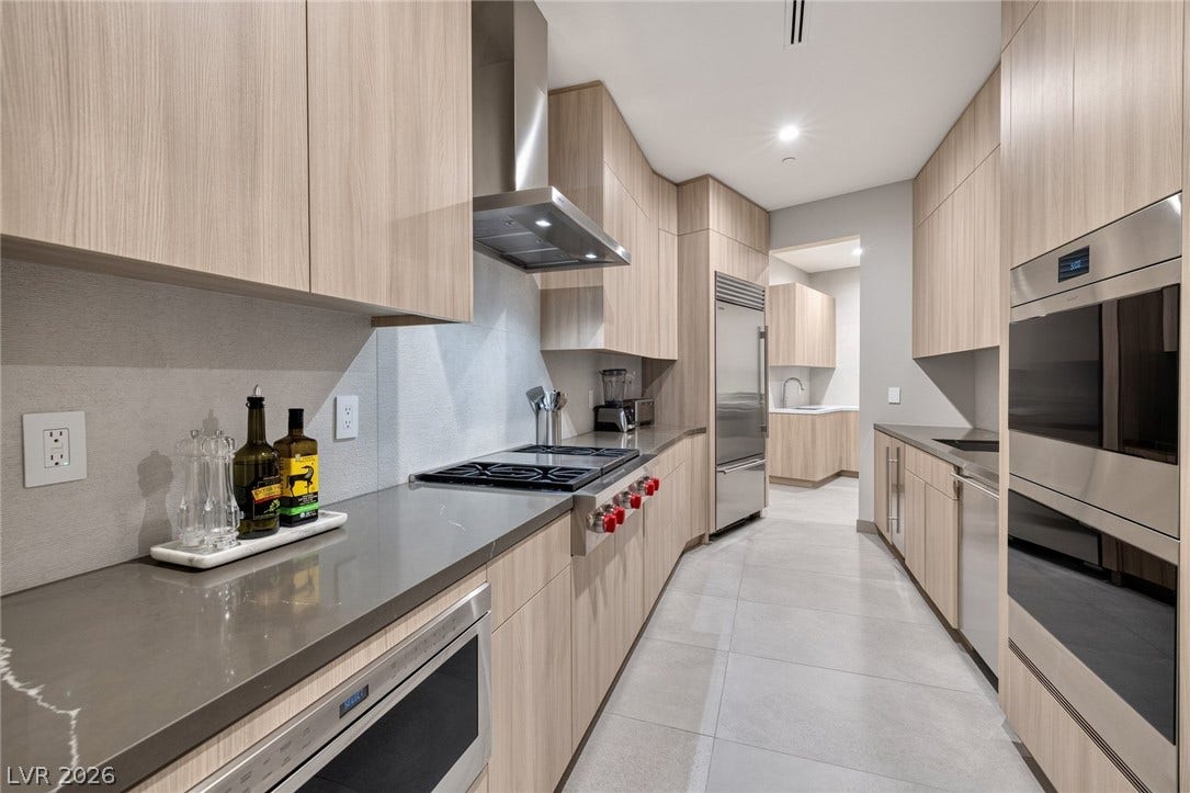 705 Dragon Peak Drive, Henderson, NV 89012 Sleek modern cabinetry and premium integrated appliances define this galley-style kitchen space.