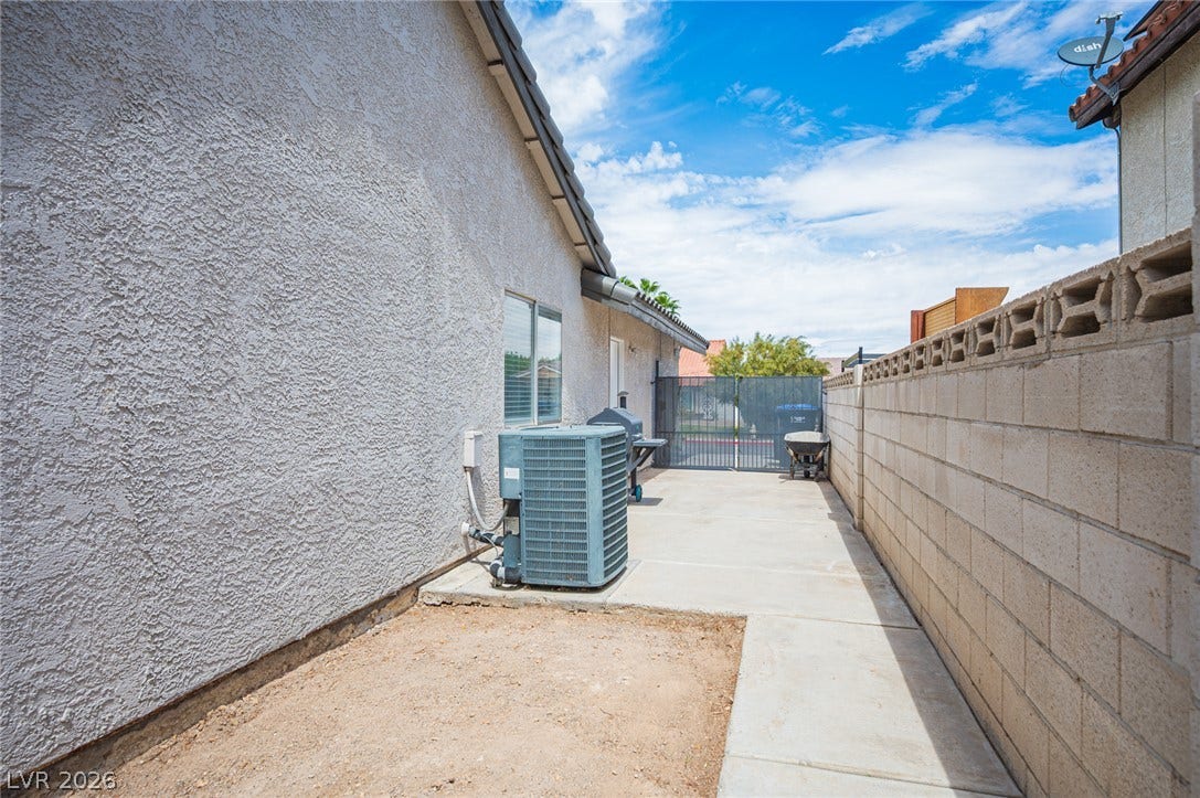 3139 Regal Oak Drive, Henderson, NV 89014 A concrete walkway sits nestled between a durable stucco exterior wall and a block privacy wall.