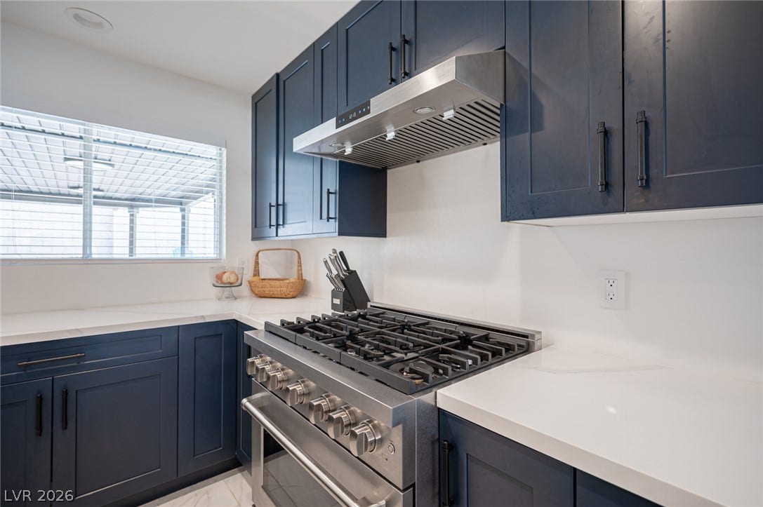3139 Regal Oak Drive, Henderson, NV 89014 Crisp solid countertops and custom shaker cabinetry surround a professional stainless steel range.