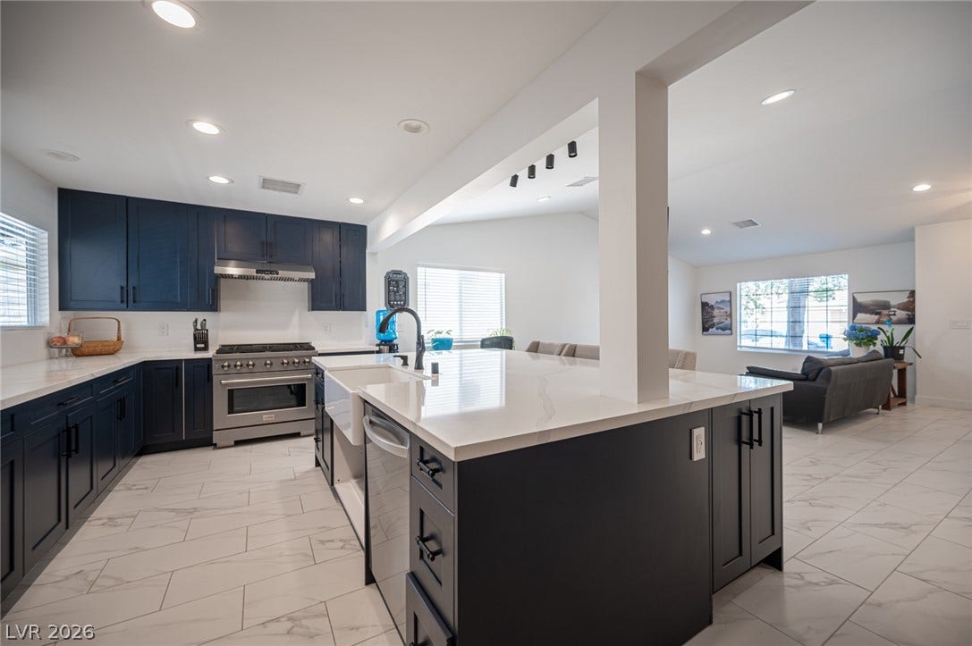 3139 Regal Oak Drive, Henderson, NV 89014 An open kitchen showcases sleek modern cabinetry, quartz countertops, and polished tile flooring.