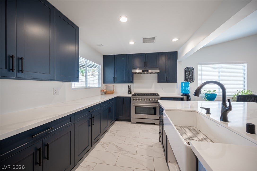 3139 Regal Oak Drive, Henderson, NV 89014 Gleaming stone countertops and modern cabinetry highlight this custom kitchen space.