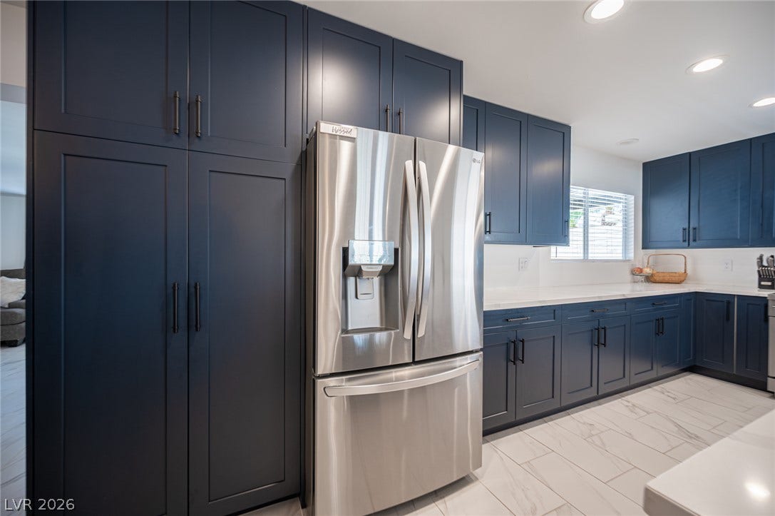 3139 Regal Oak Drive, Henderson, NV 89014 Richly toned cabinetry and sleek countertops frame this contemporary kitchen space.