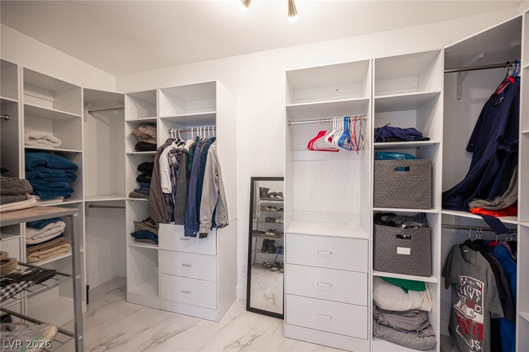 3139 Regal Oak Drive, Henderson, NV 89014 A spacious custom walk-in closet boasts marble-patterned flooring and extensive integrated organization systems.