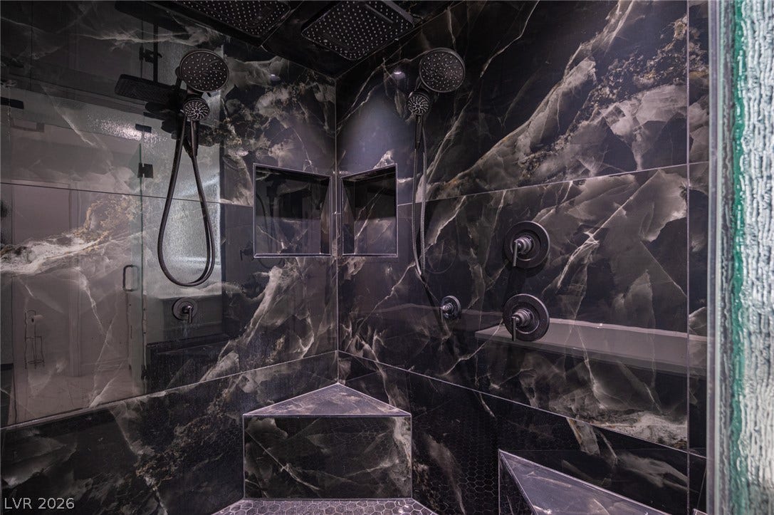 3139 Regal Oak Drive, Henderson, NV 89014 Dramatic dark marble tile walls and dual showerheads elevate this luxurious walk-in shower experience.