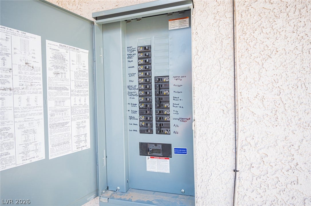 3139 Regal Oak Drive, Henderson, NV 89014 An updated electrical service panel with labeled breakers is mounted on the stucco exterior wall.