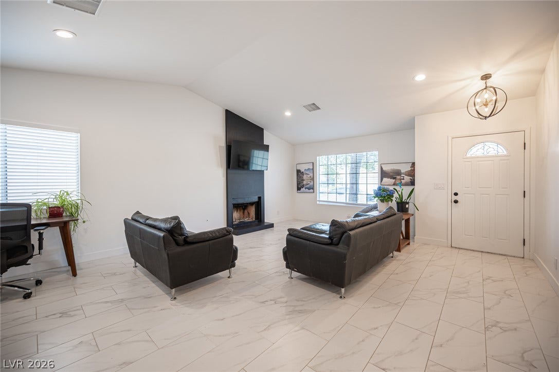 3139 Regal Oak Drive, Henderson, NV 89014 Gleaming tile floors and vaulted ceilings define this welcoming entryway and fireplace-centered living area.