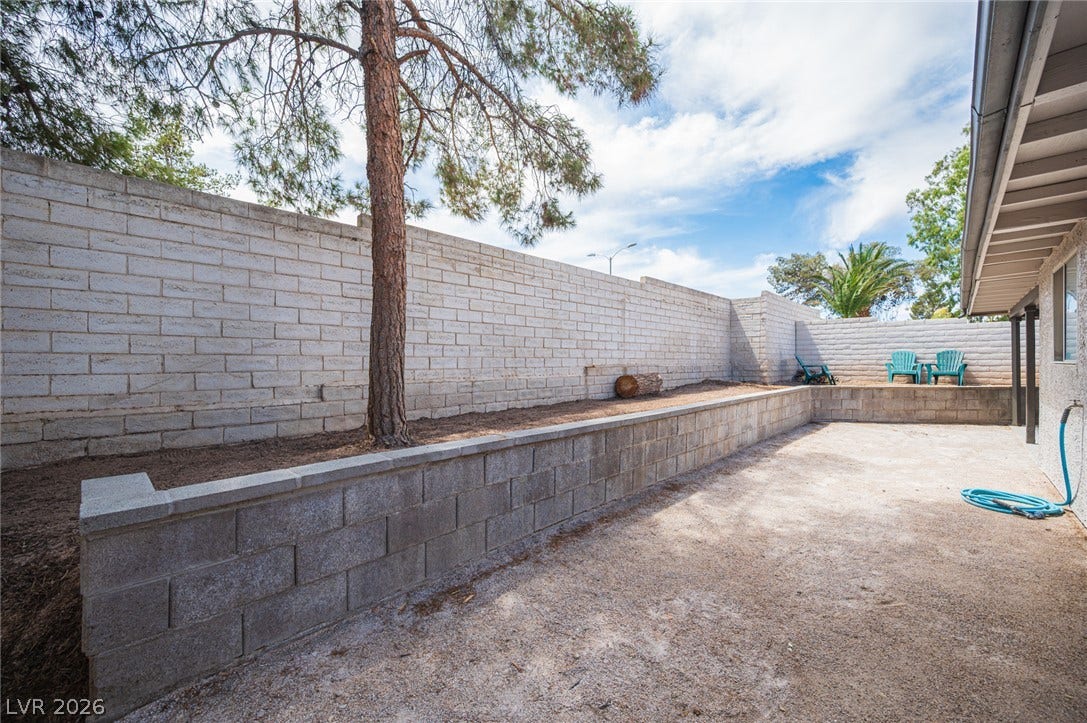 3139 Regal Oak Drive, Henderson, NV 89014 An enclosed backyard features sturdy block retaining walls and a gravel patio area.