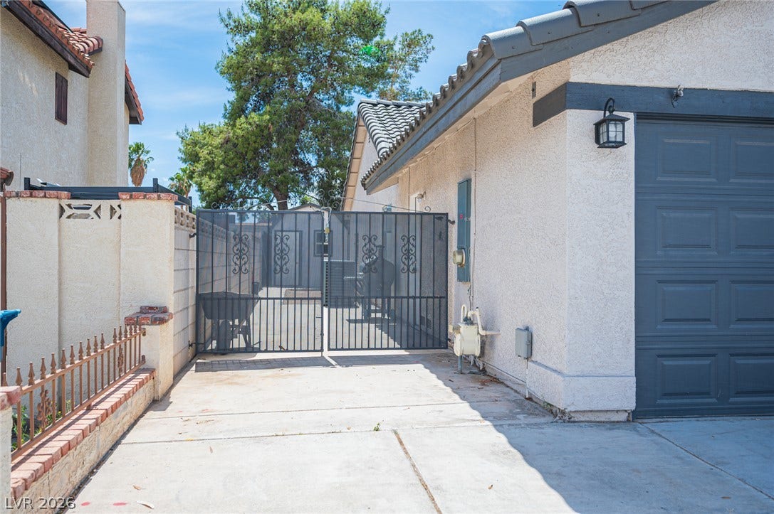 3139 Regal Oak Drive, Henderson, NV 89014 A secure gated driveway offers access alongside classic stucco construction and durable tile roofing.