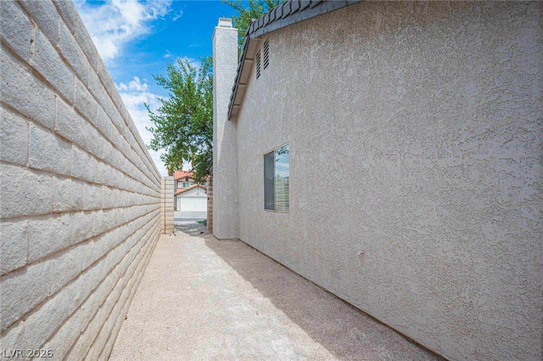 3139 Regal Oak Drive, Henderson, NV 89014 A paved side pathway is lined by a textured block wall and stucco exterior finish.