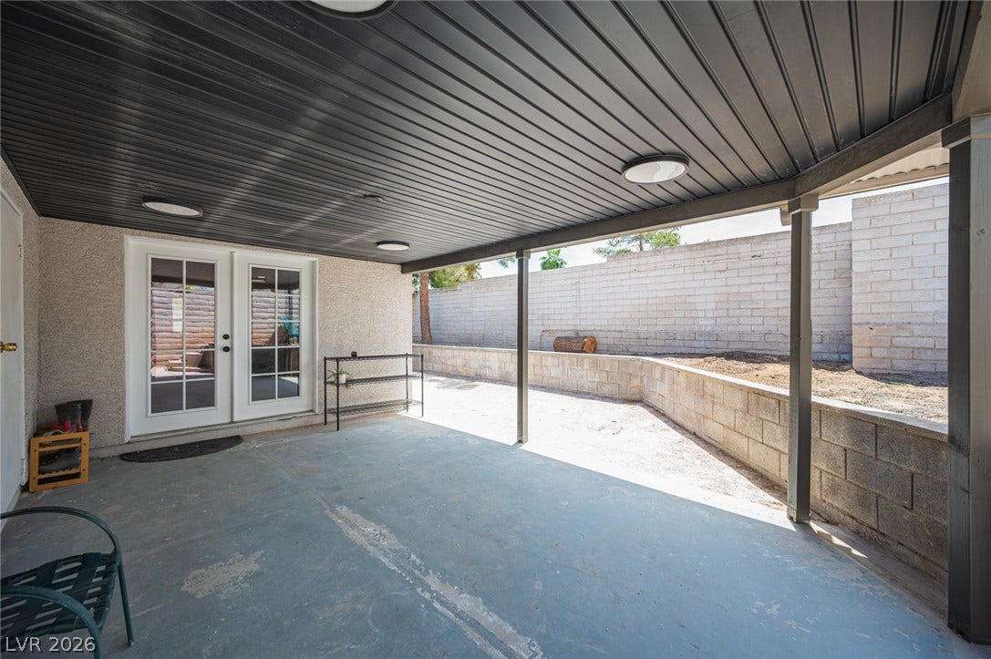 3139 Regal Oak Drive, Henderson, NV 89014 A sheltered concrete patio opens directly to the backyard through elegant glass-paned French doors.